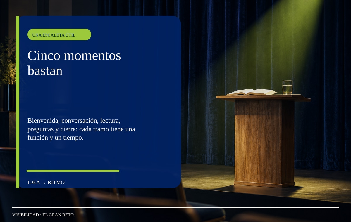 Dos sillas vacías frente a un pequeño escenario con telón azul y luz cálida